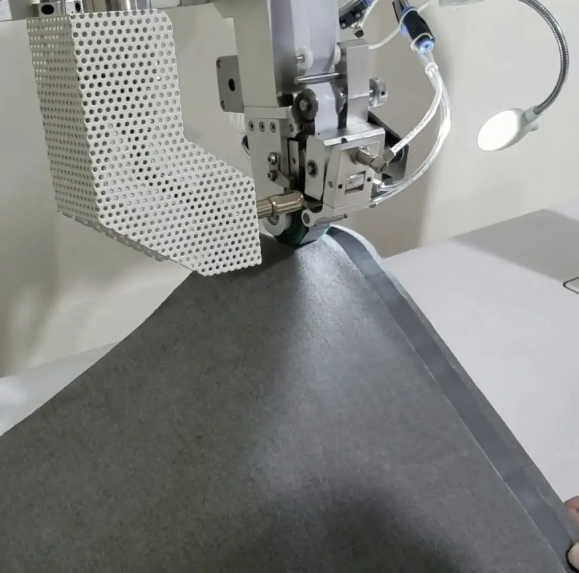 Machine in factory that creates seams on clothing
